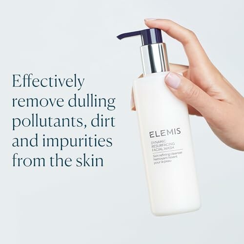 Hand holding Elemis facial wash bottle with text about removing pollutants and impurities.