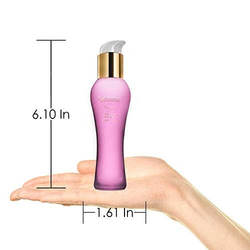 Hand holding pink skincare bottle with dimensions marked