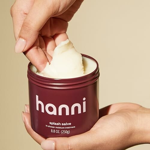 Hands holding and scooping cream from Hanni splash salve jar.