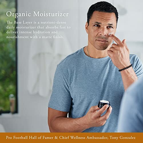 Man applying organic moisturizer to his face in a bathroom.