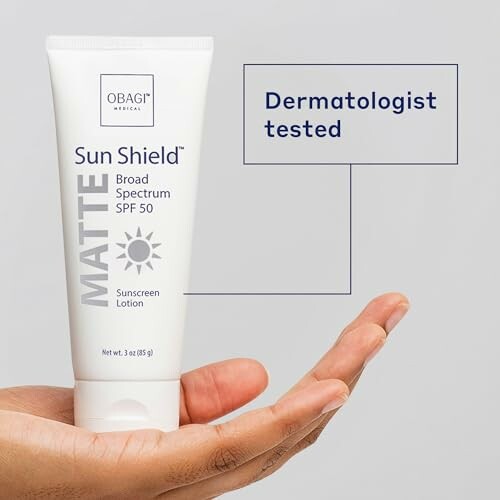 Hand holding Obagi Sun Shield Matte SPF 50 sunscreen tube.