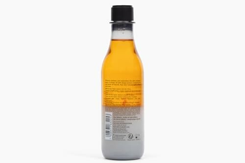 Plastic bottle filled with amber liquid on white background