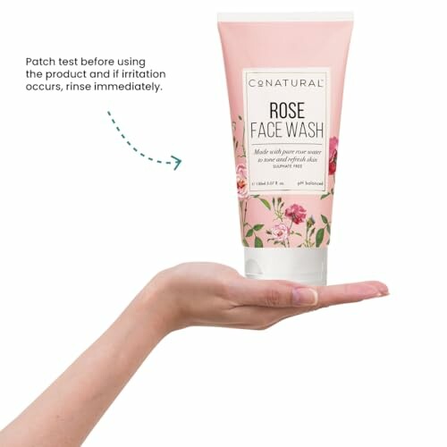 Hand holding Conatural Rose Face Wash with patch test advice.