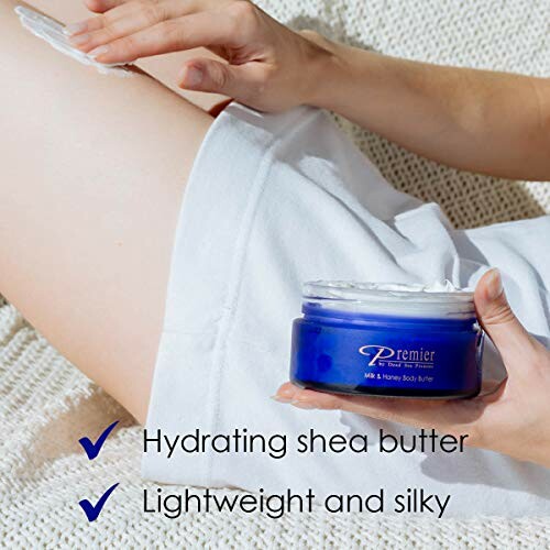 Person applying Premier shea butter body cream on leg