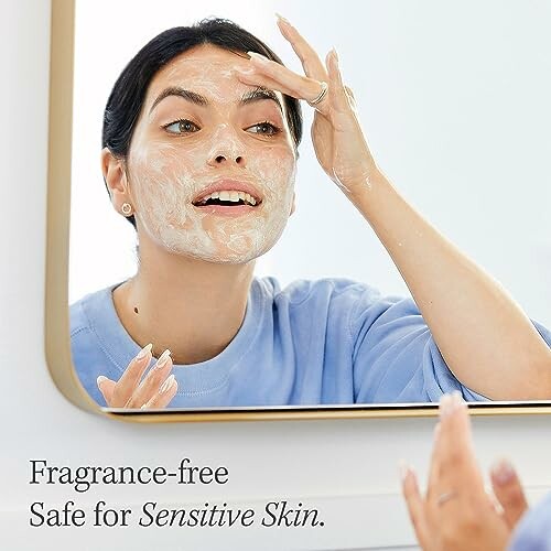 Woman applying skincare product in front of mirror.