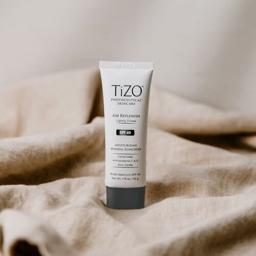 Tube of TiZO AM Replenish SPF 40 sunscreen on fabric