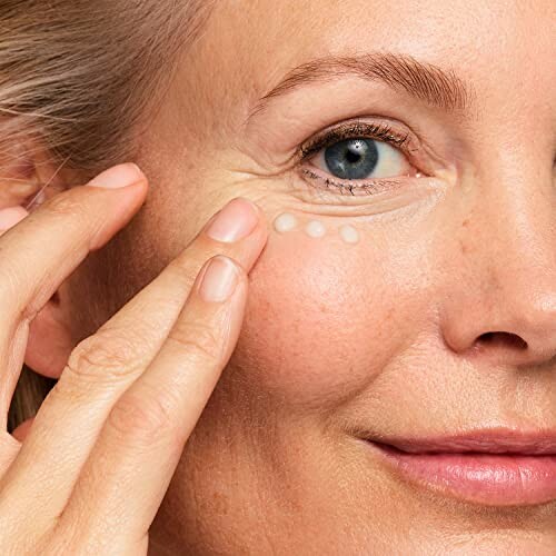 Woman applying eye cream to under-eye area